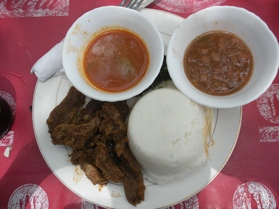 Ugali, served here with beef and sauce, is a mainstay of the cuisine throughout the African Great Lakes region.