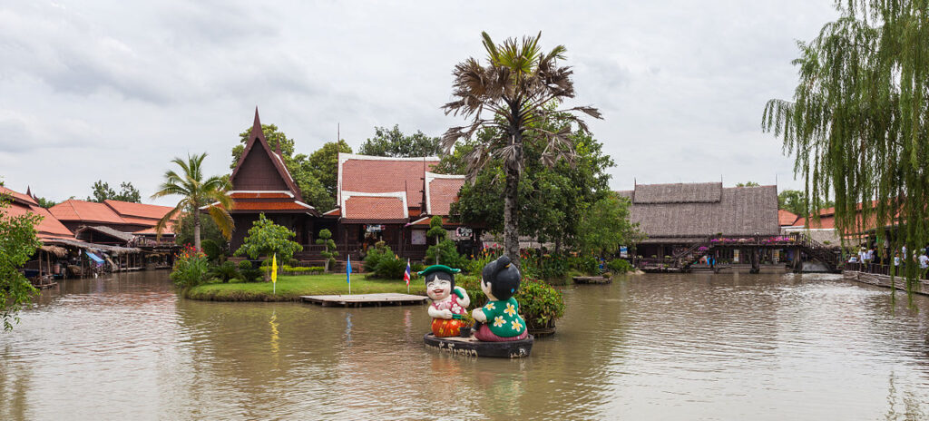 Traditional Thai wooden houses and two Thai child's dolls at Ayothaya floating market, another renowned floating market in Thailand